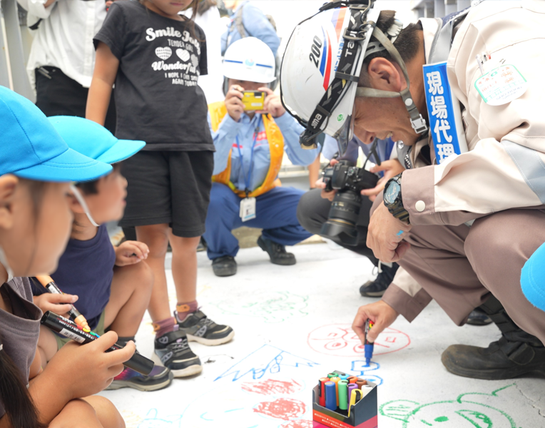 現場代理人が保育園児とともに絵を描く様子